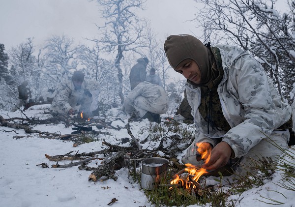 Tolga, Norway. (October 5, 2022):  In this photo by Marine Sergeant Robin Lewis, U.S. Marines with the 2nd Marine Expeditionary Force boil snow for drinking water while participating in training to increase familiarity with and proficiency operating in Arctic conditions alongside our allies and partners. Throughout history, weather has proven to be both friend and foe to military forces, often determining the outcome of the battle.