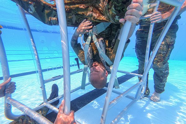 Capt. Chase Todd, 40th Helicopter Squadron pilot, holds his breath under water during underwater egress training in the base pool at Malmstrom Air Force Base, Mont., Aug. 3, 2023. The training is essential for placing aircrew in a psychologically and physiologically challenging situation and mandatory every three years. (U.S. Air Force photo by Senior Airman Mary Bowers) 