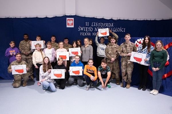 U.S. Army Soldiers with Bravo “Barbarian” Company, 2nd Battalion, 69th Armored Regiment, 2nd Armored Brigade Combat Team, 3rd Infantry Division, and the students of Primary School Cardinal Stefan Wyszyński show off the crafts they made together in Rożyńsk Wielki, Poland, Nov. 15, 2023. Task Force Marne Soldiers met with students and faculty to learn more about each other’s cultures. The 3rd Infantry Division’s mission in Europe is to engage in multinational training and exercises across the continent, working alongside NATO allies and regional security partners to provide combat-credible forces to V Corps, America’s forward deployed corps in Europe. (U.S. Army photo by Sgt. Cesar Salazar Jr.)