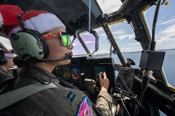 U.S. Air Force Capt. Miranda Bapty, 36th Expeditionary Airlift Squadron Operation Christmas Drop 2023 (OCD 23) deputy mission commander, flies over the Republic of Palau, Dec. 3, 2023, during OCD 23. The aircraft, callsign Santa 36, delivered two bundles to the people of Koror. OCD is the longest-running Department of Defense humanitarian and disaster relief mission. Each year, the USAF partners with countries in the Pacific Air Forces area of responsibility to deliver supplies to remote islands in the South-Eastern Pacific. (U.S. Air Force photo by Yasuo Osakabe)