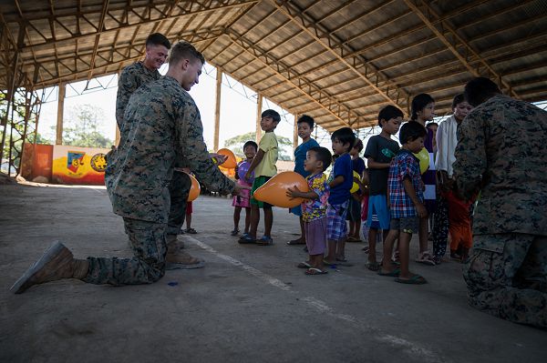 U.S. Marine Lance Cpl. Tristan Steckl (center) hands a young boy a balloon during a community relations event in support of Exercise Balikatan at Calangitan Elementary School in Capas, Tarlac, Philippines, April 23, 2018. Steckl is a combat engineer with Alpha Company, 9th Engineer Support Battalion, and is a 20-year-old native of Waukesha, Washington. Balikatan 34-2018, in its 34th iteration, is an annual U.S.-Philippine military training exercise focused on a variety of missions, including humanitarian assistance and disaster relief, counterterrorism and other combined military operations held from May 7 to 18. (U.S. Marine Corps photo by Sgt. Matthew J. Bragg)