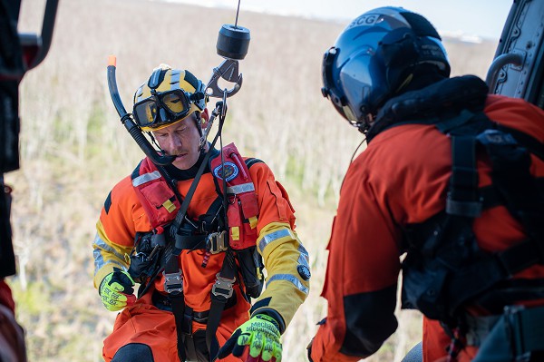 Petty Officer 2nd Class Richard Hoefle, a rescue swimmer assigned to Coast Guard Air Station New Orleans, is lowered from an MH-60 Jayhawk by Petty Officer 2nd Class Hunter Simpson, a flight mechanic at Air Station New Orleans, near New Orleans, Louisiana on Jan. 26, 2023. The MH-60 aircrew launched from Naval Air Station Joint Reserve Base New Orleans to conduct a flyover of New Orleans and emergency landing and hoist training. (photo by Petty Officer 3rd Class Gabriel Wisdom)