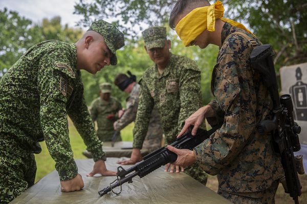 U.S. Marines with Lima Company 3rd Battalion, 23rd Marine Regiment, Marine Corps Forces Reserve, race to assemble and disassemble the Colombian standard-issue rifle under the guidance of Colombian instructors during UNITAS LXIV aboard Escuela de Formación de Infantería Marina Coveñas in Coveñas, Colombia, July 12, 2023. The blindfolds add an extra challenge after the Marines have already familiarized themselves with the Colombian standard-issue rifles. UNITAS focuses on strengthening our existing regional partnerships and encouraging the establishment of new relationships through the exchange of maritime mission-focused knowledge and expertise. (U.S. Marine Corps photo by LCpl. Samuel Qin)