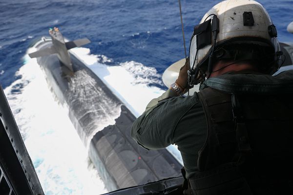 U.S. Marine Corps Staff Sgt. Joseph McDonnell, a crew chief with Marine Heavy Helicopter Squadron (HMH) 462, 1st Marine Aircraft Wing, III Marine Expeditionary Force, lowers a package to the Ohio-class ballistic missile submarine USS Maine (SSBN 741) during a vertical replenishment (VERTREP) in the Philippine Sea, May 9, 2023. Vertical replenishments enable naval vessels to quickly receive critical resources without disrupting maritime security operations while underway. III MEF is postured to enable naval expeditionary operations within the first island chain as part of a Stand-in-Force. (U.S. Marine Corps photo by Lance Cpl. Emily Weiss)