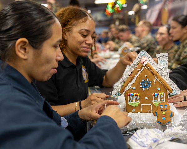 NORFOLK (Dec. 6, 2023) Interior Communications Electrician 2nd Class Paola Diaz, left, and Retail Specialist Seaman Nadya Lowder decorate a gingerbread house on the mess decks aboard the amphibious assault ship USS Wasp (LHD 1), Dec. 6, 2023. Wasp held a gingerbread cookie decorating event for Sailors and Marines. Wasp is in Naval Station Norfolk participating in Amphibious Squadron/Marine Expeditionary Unit Integration (PMINT) during Integrated Phase inspections and assessments in preparation for a scheduled future deployment. (U.S. Navy photo by Mass Communication Specialist Seaman Justin Kemble)