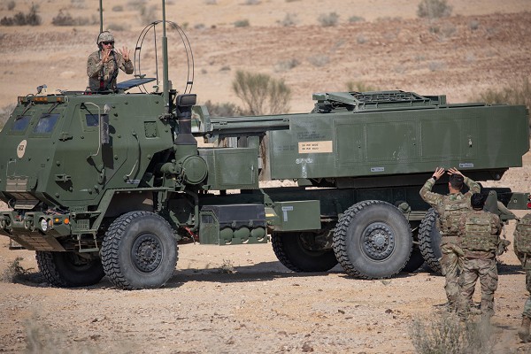 A Soldier with 2nd Battalion, 130th Field Artillery Regiment, Task Force Spartan, communicates with Soldiers from his battalion through hand signals from the air guard hatch of their High Mobility Rocket Artillery System during exercise Juniper Oak 2023. The exercise is a large-scale bilateral multi-domain military exercise aimed to enhance interoperability between U.S. and Israeli armed forces contributing to integrated regional security (photo by Spc. David Campos-Contreras).