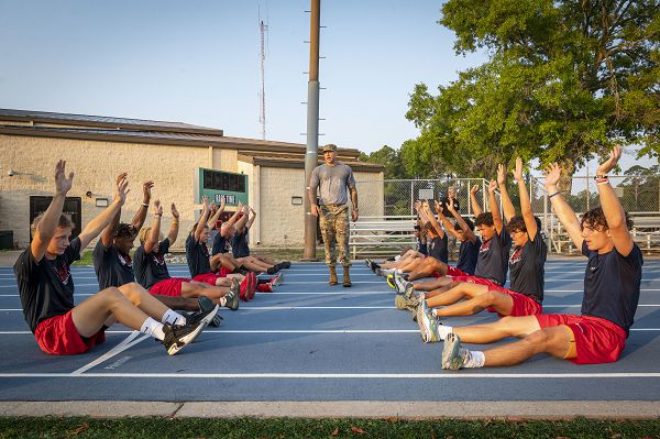Master Sgt. Bradley Sheppard, 36th Electronic Warfare Squadron flight chief, conducts a basic military training-style exercise session for members of the Fort Walton Beach High School Vikings football team during Air Commando Youth Athletic Camp at Hurlburt Field, Fla., July 19, 2023. For the three-day football camp, the team trained alongside Airmen performing formation runs, military drills and military tent building as an opportunity to learn the 1st Special Operations Wing’s mission. (U.S. Air Force photo by Staff Sgt. Miranda Mahoney) 