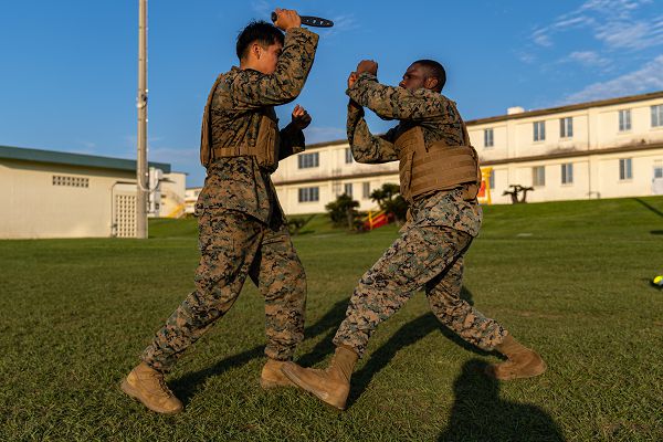 U.S. Marine Corps Cpl. Alberto Gutierrez, left, a cryogenics equipment operator, and Cpl. Olayinka Okenmakinde, an aircraft maintenance support equipment electrician and refrigeration mechanic, both with Marine Wing Liaison Kadena, 1st Marine Aircraft Wing, perform knife techniques during a Marine Corps Martial Arts Program (MCMAP) course on Camp Foster, Okinawa, Japan, May 11, 2023. MCMAP consists of combat conditioning, close-quarter and hand-to-hand combat techniques to ensure each Marine becomes a more effective war fighter. (U.S. Marine Corps photo by Cpl. Kyle Chan)  
