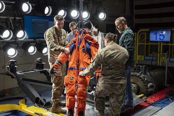 Air Force Research Laboratory personnel and NASA staff hoist Campos, a fire and rescue training manikin, into a seat at Wright-Patterson Air Force Base, Ohio, April 17, 2023. AFRL and NASA tested the most current iteration of an astronaut crew seat and flight suit that will be used on the Orion space capsule during the next mission to the moon under the Artemis Program. (U.S. Air Force photo byRichard Eldridge)