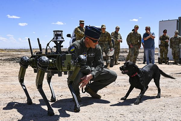 Col. Justin Spears, 49th Wing commander, introduces his dog, Blue, to a Vision 60 Q-UGV ground robot at Holloman Air Force Base, N.M., April 17, 2023. The Vision 60 is a quadrupedal ground robot that is capable of maneuvering through rough terrain, making it perfect for patrolling Holloman AFB’s arid environment. (U.S. Air Force photo by Airman 1st Class Isaiah Pedrazzini) 