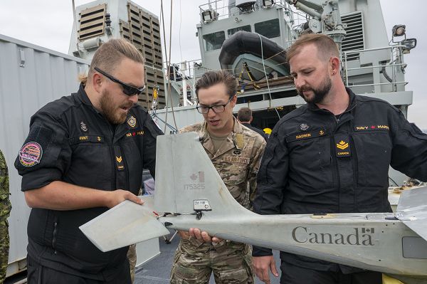 Senior Airman Michael Harbeck, 824th Base Defense Squadron fire team member, discusses Puma Unmanned Aerial System operations with members of the Royal Canadian Navy during Exercise Agile Blizzard-Unified Vision 2023 aboard a RCN vessel near British Columbia, Canada, June 21, 2023. Both the U.S. Air Force and RCN operate the Puma UAS and were able to pass on different techniques, tactics and procedures to build the capabilities of both forces and enhance joint partnerships. (U.S. Air Force photo by Tech. Sgt. Betty R. Chevalier)  