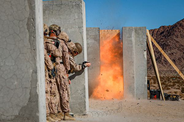 U.S. Marines ignite an explosive breach during a squad urban fundamentals course for an adversary force exercise at Marine Corps Air-Ground Combat Center, Twentynine Palms, California, Dec. 05, 2024. The AFX is the primary readiness-building event prior to Echo Company, 2nd Battalion, 23rd Marine Regiment’s upcoming deployment to Okinawa, Japan, in support of the Marine Corps’ Unit Deployment Program. The exercise serves as an opportunity to receive training across all warfighting functions in a realistic and fully resourced environment. (U.S. Marine Corps photo by Lance Cpl. Orion Stpierre)