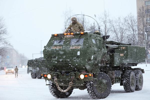 U.S. Army  Sgt. Cade England, a M142 High Mobility Artillery Rocket System (HIMARS) gunner operator assigned to Able Battery, 3rd Battalion, 321st Field Artillery Regiment, 18th Field Artillery Brigade, communicates with the driver in Narva, Estonia, Jan. 3, 2025. England supported Task Force Voit and Task Force Pegasus during a static display showcasing the HIMARS capabilities to the public. The event highlighted the importance of U.S. troops engaging with local communities to strengthen bonds and assure NATO allies of ongoing partnership and cooperation. (U.S. Army photo by Staff Sgt. Rose Di Trolio)
