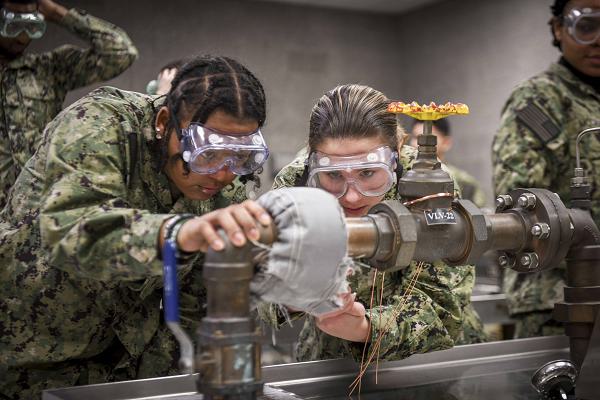 GREAT LAKES, Ill. (December 16, 2024) Accession-level Sailors practice installing a flange shield on a valve at the Surface Warfare Engineering Schools Command Great Lakes Engineering Professional Apprenticeship Career Track (E-PACT) course aboard Naval Station Great Lakes, December 16, 2024. E-PACT is a program that allows enlisted Sailors to gain formal training and on-the-job experience to eventually earn a permanent Navy rating or career field. (U.S. Navy photo by Mass Communication Specialist 2nd Class Matt Hall)