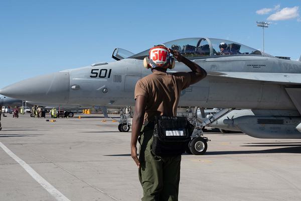U.S. Navy Aviation Ordnanceman 3rd Class Keyon Griffin, assigned to Electronic Attack Squadron (VAQ) 209, Naval Air Station Whidbey Island, Washington, salutes a U.S. Navy EA-18G Growler as it taxis out to support Red Flag-Nellis 25-1 during at Nellis Air Force Base, Nevada, Feb. 5, 2025. Exercises like Red Flag, provide aircrews the experience of multiple, intensive air combat sorties in the safety of a training environment. (U.S. Air Force photo by Senior Airman Jordan McCoy)