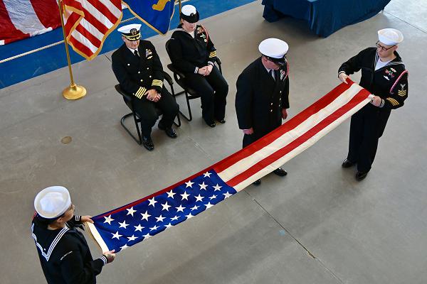 Staff members assigned to Surface Combat Systems Training Command Great Lakes fold the American Flag during a retirement ceremony at Naval Station Great Lakes. Flag-folding ceremonies are symbolic displays of respect that have developed into rich military traditions. Flag handlers fold the American Flag 13 times representing the 13 original colonies of the United States.