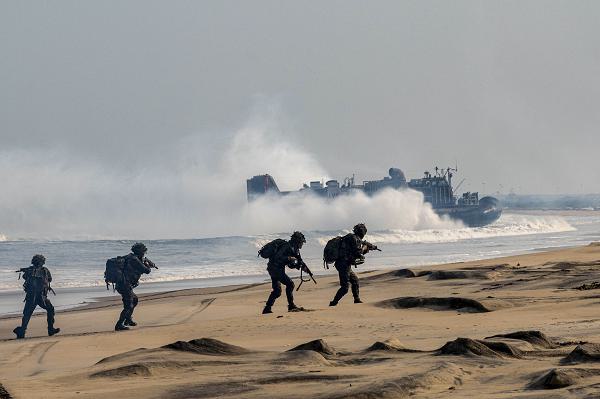 Indian Army soldiers from the 4/8 Gurkha Rifles Infantry Battalion, 91st Infantry Brigade, simulate securing a beach before a U.S. Navy Landing Craft, Air Cushion launched from the Whidbey Island-class dock landing ship USS Comstock (LSD 45) arrives during a large-scale amphibious landing drill as part of Exercise Tiger Triumph, at Kakinada Beach, Andhra Pradesh, India, April 11, 2025. Tiger Triumph is a joint and combined U.S.-India exercise focused on humanitarian assistance and disaster response readiness and interoperability. Tiger Triumph enables U.S. and Indian armed forces to improve interoperability and bilateral, joint, and service readiness in the Indian Ocean region and beyond to support a free and open Indo-Pacific. (U.S. Air Force photo by Staff Sgt. Aaron Irvin)