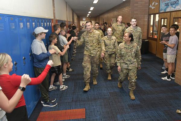 (Center) Capt. Aaron Peters, 75th Civil Engineer Squadron, fist-bumps students during a military parade April 11, 2025, at Syracuse Junior High School in Syracuse, Utah. Active-duty military from Hill Air Force Base and local veterans participated in the parade, which aimed to celebrate military families during Month of the Military Child in April. (U.S. Air Force photo by Todd Cromar)