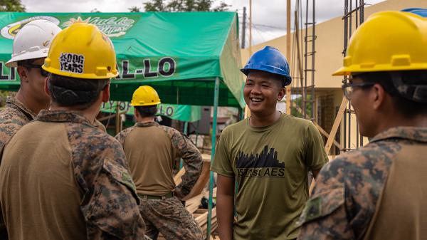 Philipine Air Force A2C Melvin Mendoza, an engineer with the 357th Air Engineering Squadron, laughs alongside U.S. Marine Corps combat engineers assigned to Marine Wing Support Squadron 174, Marine Aircraft Group 24, 1st Marine Aircraft Wing, at a construction site during Exercise Balikatan 25 at the Barangay Dagupan Multipurpose Gymnasium, Lal-lo, Cagayan, Philippines, April 8, 2025. Balikatan is a longstanding annual exercise between the Armed Forces of the Philippines and the U.S. military designed to strengthen our ironclad alliance, improve our capable combined force and demonstrate our commitment to regional security and stability (U.S. Marine Corps photo by Lance Cpl. Roger- Junior Annoh)   