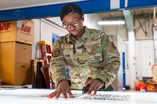 Airman 1st Class Alavinia Dishmond, 341st Civil Engineer Squadron structural apprentice, cuts a piece of vinyl April 9, 2025, at Malmstrom Air Force Base, Mont. Malmstrom’s sign makers design and produce custom signs that support base operations, safety and communication. (U.S. Air Force photo by Senior Airman Mary Bowers) 