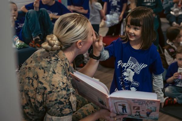 U.S. Marine Corps Capt. Riley Tejcek, logistics officer, Marine Corps University, high fives a child during the “Dream Big with Riley” event at the Main USO Center, Marine Corps Base Quantico, Virginia, April 9, 2025. Capt. Riley Tejcek reads her new children’s book ‘If You Can Dream It, Be It.’ to children for the Marine Trailblazer to Read Empowering Children’s Books to Military Children during the Month of the Military Child. (U.S. Marine Corps photo by Lance Cpl. Ethan Miller)