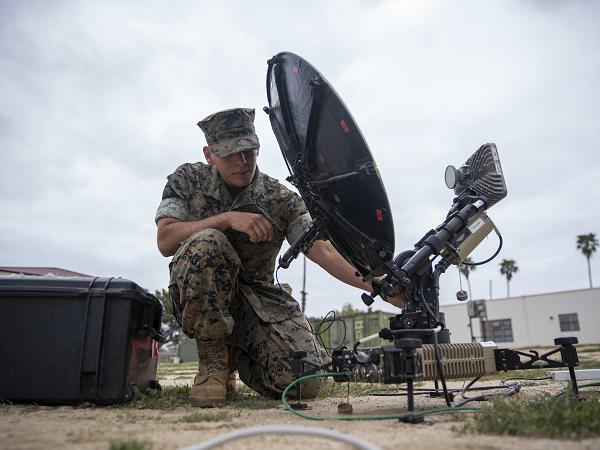 U.S. Marine Corps Lance Cpl. Ricardo Ramirez, a radio operator assigned to the 15th Marine Expeditionary Unit, I Marine Expeditionary Force, operates a multi-mission terminal (MMT)   during a command post exercise on Marine Corps Base Camp Pendleton, April 23, 2025. The MMT is a rapidly deployable, software-defined system that provides broadband connectivity across multiple satellite networks, enabling secure communications in support of expeditionary operations. The CPX allowed the 15th MEU to develop best practices for command and control of forces from a shore-based location to test systems, evaluate processes, develop techniques, and validate standard operating procedures. (U.S. Marine Corps photo by Sgt. Patrick Katz)