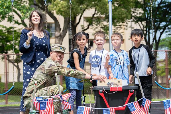 From left, Nikki Palmer, Space Systems Command chief engineer, and U.S. Space Force Lt. Col. Kaoru Elliott, U.S. Space Forces-Japan deputy commander, watch rocket launches with Yokota West Elementary School students during an SSC STEM outreach at Yokota Air Base, Japan, May 15, 2025. The SSC team visited Department of Defense schools overseas for the first time, expanding its outreach beyond the continental U.S. and reinforcing its commitment to engaging military-connected students in science, technology, engineering and math education. (U.S. Air Force photo by Airman 1st Class David S. Calcote)