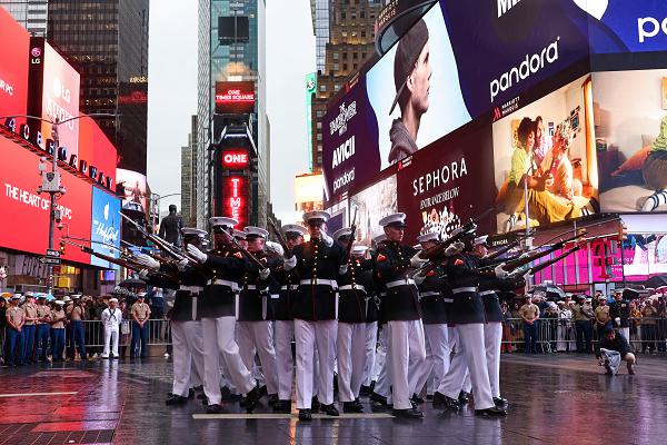 U.S. Marines with the United States Marine Corps Silent Drill Platoon execute their "bursting bomb" sequence during their performance in Times Square, New York City, N.Y., May 21, 2025. The Silent Drill Platoon helped kick off Fleet Week New York with a performance in Times Square. Fleet Week New York is an annual celebration where U.S. Navy, Marine Corps, and Coast Guard ships dock in New York City, allowing the public to tour vessels and meet service members. By participating in ceremonies like this, Marine Barracks Washington connects the traditions of the Marine Corps with the American people they serve. (U.S. Marine Corps photo by Lance Cpl. Christopher Prelle)