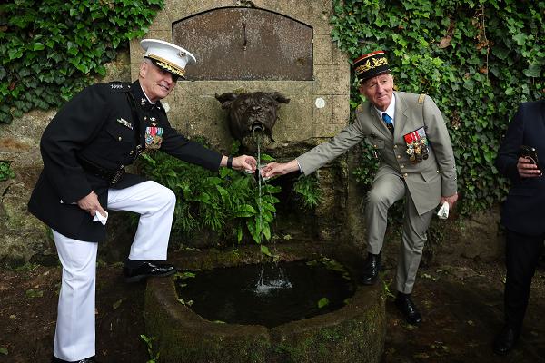 U.S. Marine Corps Gen. Christopher Mahoney, the Assistant Commandant of the Marine Corps, left, and a French key leader, right, drink from Devil Dog Fountain in Belleau Wood, France, May 25, 2025. The memorial ceremony was held in commemoration of the 107th anniversary of the battle of Belleau Wood, conducted to honor the legacy of service members who gave their lives in defense of the United States and European allies. (U.S. Marine Corps photo by Cpl. Garrett Gillespie)