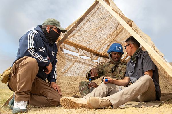 U.S. Army 1st Lt. Davonta Vaughn a platoon leader, assigned to the 390th Military Police Battalion, 11th Military Police Brigade, 200th Military Police Command and Fa Ganbaatar an interpreter speak to Mongolian Armed Forces Staff Sgt. Dadaasuren Tumen Ulzii a role player assigned to Unit 342, on foot patrol training, during Khaan Quest 2025, at Five Hills Training Area in Mongolia, June 16, 2025. Khaan Quest is an annual, multinational and multicomponent training exercise led by the Mongolian Armed Forces designed to promote regional peace and security. (U.S. Army photo by Staff. Sgt. Christopher D Stelter)
