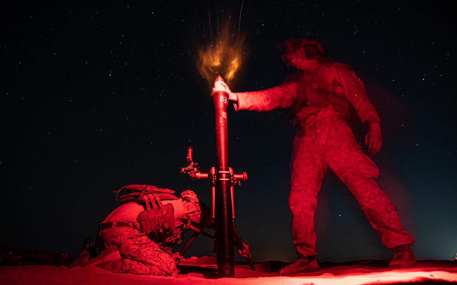 211004-M-OY155-1374 CAMP BUEHRING, Kuwait (Oct. 3, 2021) Marine Corps Lance Mitchel Trexel, left, and Lance Cpl. Drake King, mortarmen assigned to Charlie Company, Battalion Landing Team 1/1, 11th Marine Expeditionary Unit (MEU), fire an M252A2 81 mm mortar system during a night live-fire exercise, Oct. 3. The 11th MEU and Essex Amphibious Ready Group are deployed to the U.S. 5th Fleet area of operations in support of naval operations to ensure maritime stability and security in the Central Region, connecting the Mediterranean and Pacific through the Western Indian Ocean and three strategic choke points. (U.S. Marine Corps photo by Sgt. Jennessa Davey/Released)