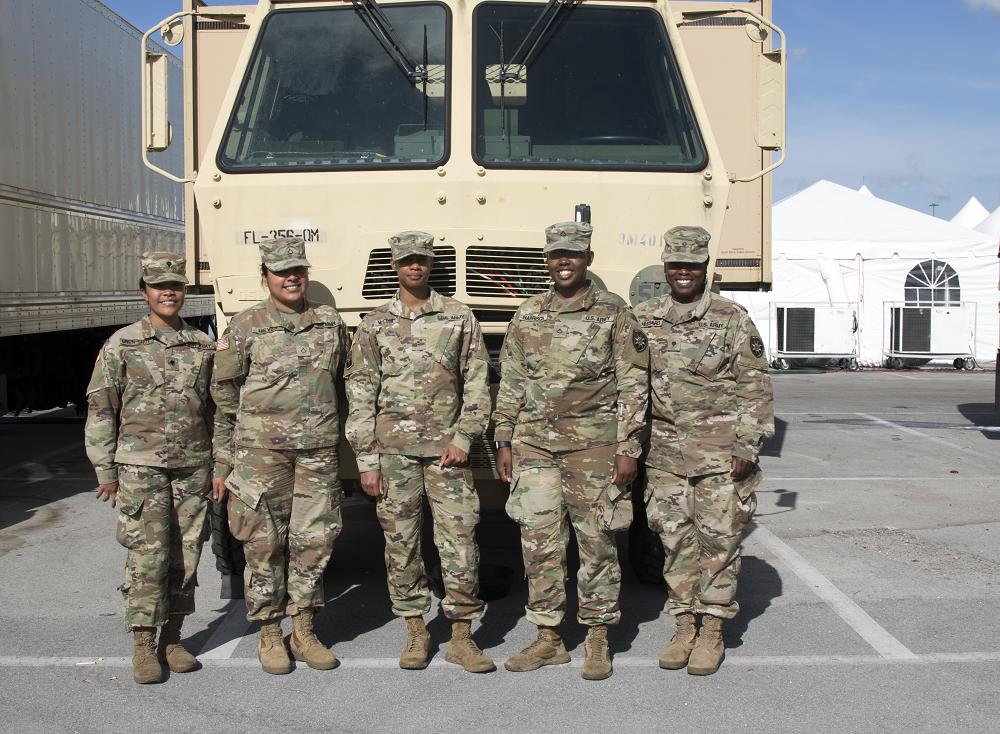 Left to right, Spc. Francesca Chen-Shue, Pfc. Monica Nieves, Chief Warrant Officer Latania McCook, Pfc. Tyanna Harrison and Spc. Taquisha Hubbard, members of the all-female 356th Quartermaster (War Wagon) Company at a COVID-19 testing site in Miami Gardens, Florida. (Photo by Sgt. Leia Tascarini)