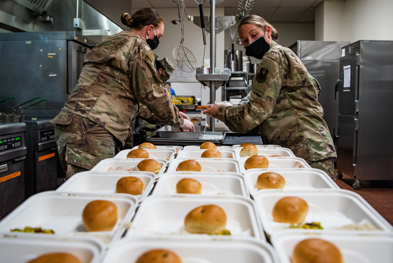 Senior Airman Margaret Dziamba, left, a fitness services specialist assigned to the 27th Special Operations Force Support Squadron, and Staff Sgt. Jordan Sexton, a food services specialist assigned to the 27 SOFSS, prepares meal containers for quarantined Airmen at the Pecos Trail Dining Facility on Cannon Air Force Base, N.M., May 15, 2020. The 27 SOFSS is responsible for preparing three hot meals a day, as well as snacks and drinks, for over 140 Airmen quarantined on Cannon. (U.S. Air Force photo by Senior Airman Maxwell Daigle)