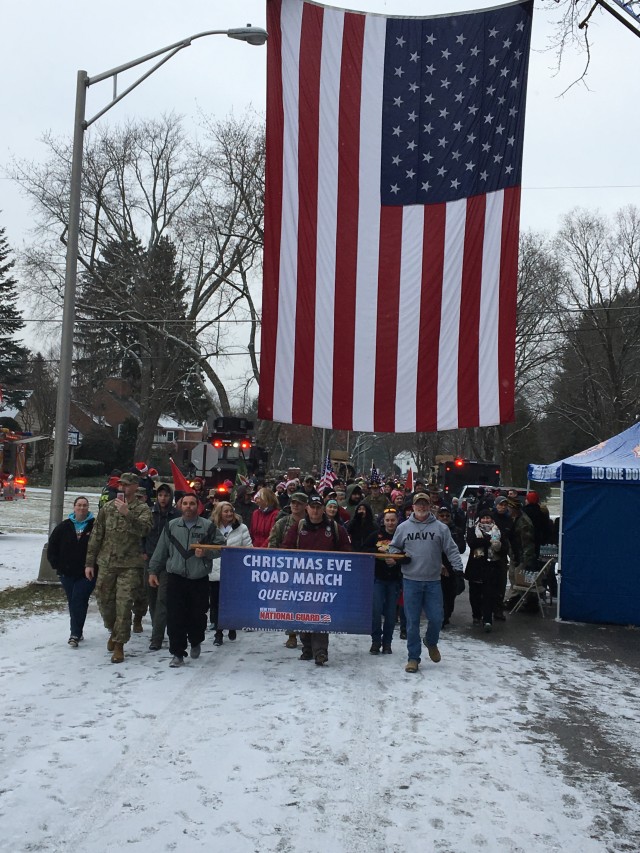 Retired New York Army National Guard Sgt. 1st Class Arthur Coon, center in red jacket, steps off for the 15th annual Christmas Eve Road March in Glens Falls, N.Y., Dec. 24, 2018. Coon has organized the annual event to honor deployed service members s... (Photo Credit: U.S. Army)