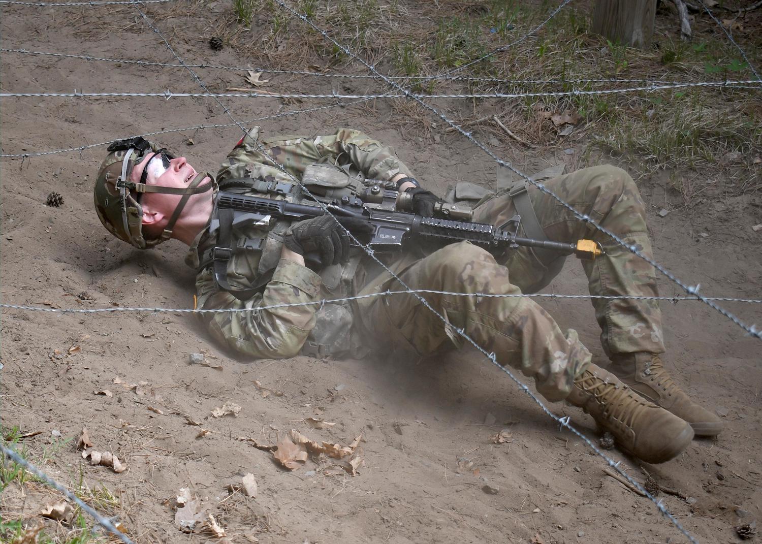 FORT DRUM, N.Y. – U.S. Army Sgt. Klayton McCallum, a combat medic with the New York National Guard’s 2nd Battalion, 108th Infantry Regiment, navigates a barbed wire obstacle during the 10th Mountain Division Expert Field Medical Badge assessment at Fort Drum, N.Y., May 20, 2021. (photo by Sgt. 1st Class Warren W. Wright Jr., New York National Guard)