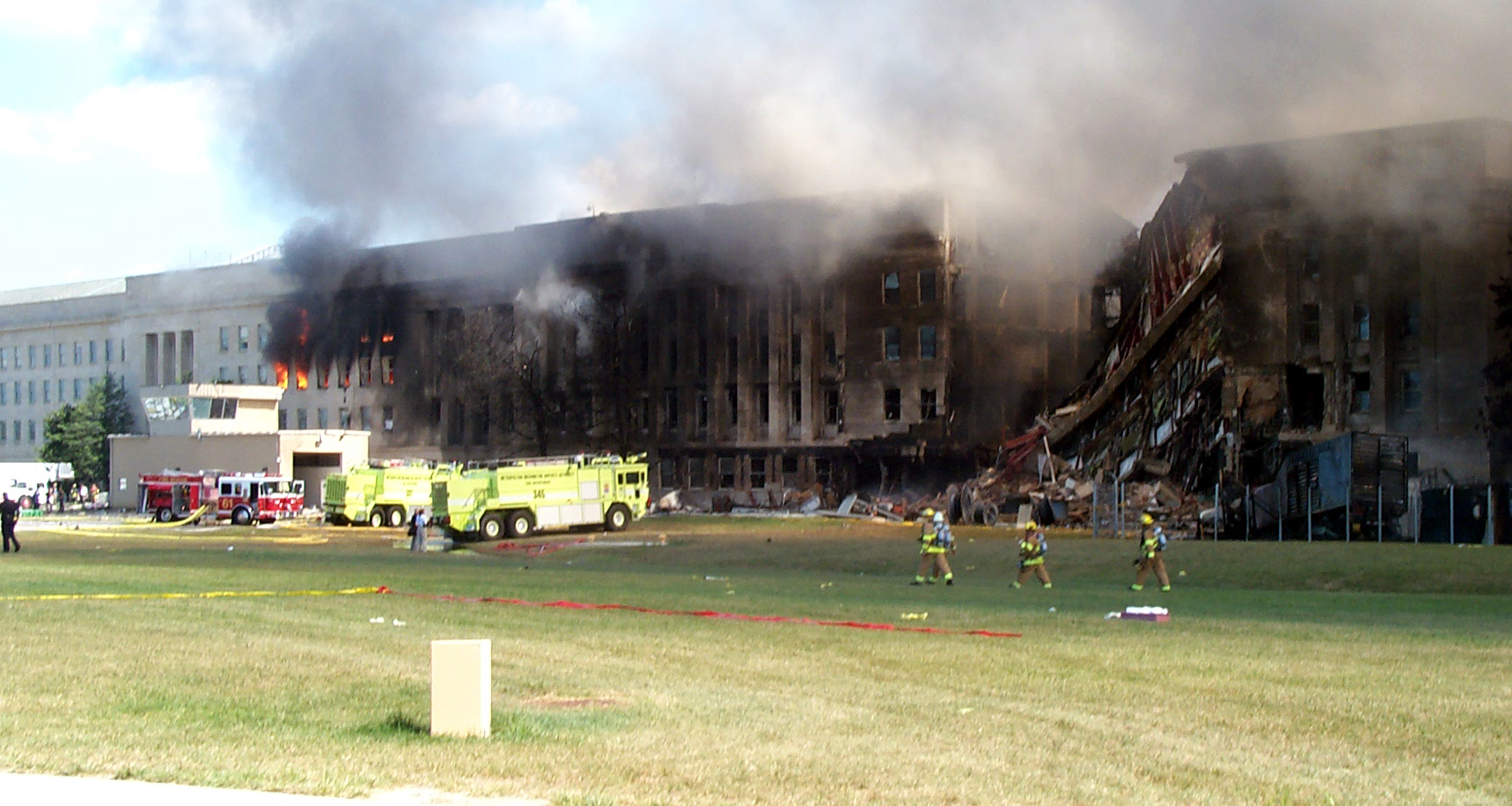 Smoke and flames rise from the Pentagon as firefighters continue to work to put out the flames. A plane struck the building Sept. 11, 2001. Witnesses said evacuation of the building was calm and orderly. Hundreds of military and civilian workers volunteered to help local medics. Photo By: Jim Garamone