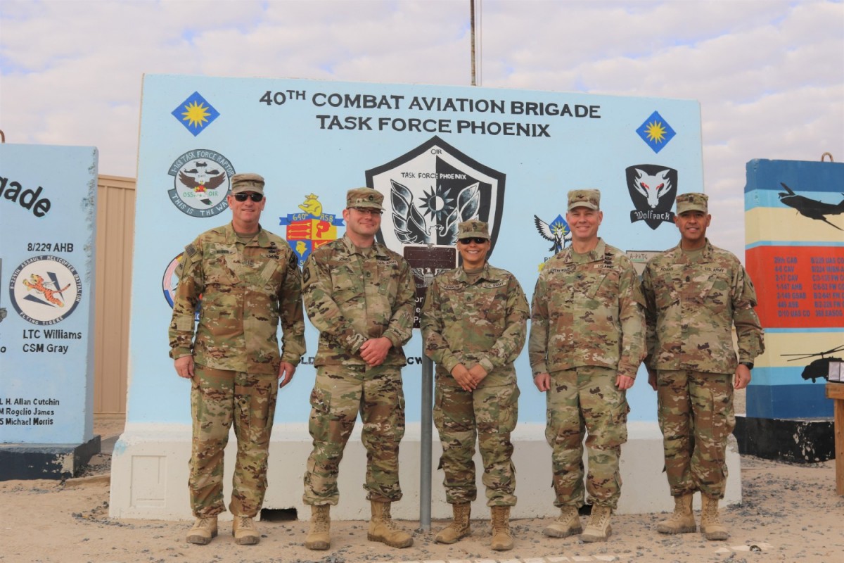 From left, Command Chief Warrant Officer 5 Rich Huber, Sgt. 1st Class Robert Jones, Staff Sgt. Vergia Farrow, Col. Alan Gronewold and Command Sgt. Maj. Refugio Rosas poses for a photo in front of the Task Force Phoenix T-wall at Camp Buehring, Kuwait. (Maj. Jason Sweeney)