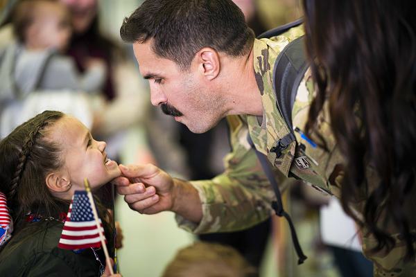 U.S. Air Force Major Christopher Valine, a pilot with the 153rd Airlift Wing, Wyoming Air National Guard, inspects his daughter’s missing teeth after a three-month deployment to U.S. Africa Command on March 5, 2024, in Cheyenne, Wyo. The primary mission of the C-130 Hercules aircraft is tactical airlift, transporting troops and cargo, which is what the airmen were responsible for during their deployment. (U.S. Air National Guard photo by Master Sgt. Jon Alderman)