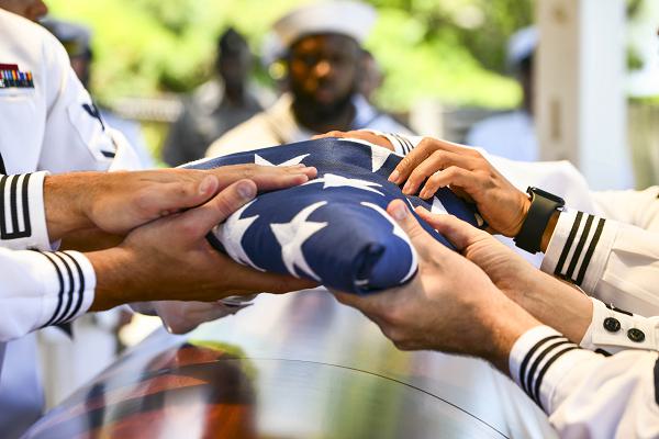 U.S. Navy Sailors assigned to Navy Region Hawaii fold an American flag during an interment ceremony held at the National Memorial Cemetery of the Pacific, Honolulu, Hawaii, May 8, 2024. The Defense POW/MIA Accounting Agency and other attendees paid their respects and honored the life of U.S. Navy Fire Controlman 1st Class Robert L. Corn, who was assigned to the USS Oklahoma when the ship was attacked by Japanese aircraft during World War II. The USS Oklahoma sustained multiple torpedo hits, which caused it to quickly capsize. Corn was accounted for on January 29, 2019. (U.S. Air Force photo by Staff Sgt. Jonathan McElderry)