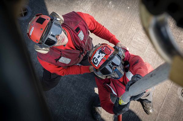 Aviation Ordnanceman 3rd Class Davonte Camp, left,  braces Aviation Ordnanceman 3rd Class Lonnie Shive as he reaches up to secure ammunition to the underside of an MH-60S Sea Hawk helicopter from Helicopter Sea Combat Squadron (HSC) 7 to facilitate the safe off-load of ordnance aboard the Nimitz-class aircraft carrier USS Dwight D. Eisenhower (CVN 69), Aug. 27. IKE is underway in the Atlantic Ocean for an ammunition transfer with the Lewis and Clark-class dry cargo ship USNS William McLean (T-AKE 12). (U.S. Navy photo by Mass Communication Specialist 2nd Class Merissa Daley)                                                                    