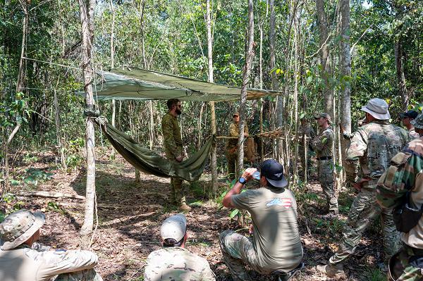 Royal Australian Air Force Cpl. Anthony Ross, Australian Defence Force Combat Survival Training School instructor, discusses the importance of well-built shelter in survival scenarios during Pacific Angel 24-1 at Port Moresby, Papua New Guinea, Aug. 27, 2024. Pacific Angel 24-1 is a bilateral operation with forces representing the U.S. Air Force, Royal Australian Air Force, and the Papua New Guinea Defence Force. During the exercise, participants will exchange knowledge and information on various topics including survival, evasion, resistance, and escape. (U.S. Air Force photo by Airman 1st Class Carson Jeney)