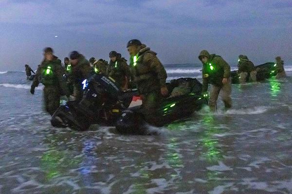 U.S. Marines with 1st Battalion, 7th Marine Regiment, 1st Marine Division, drag combat rubber raiding craft onto shore during an infantry company small boat raid course hosted by Expeditionary Warfare Training Group Pacific at Naval Amphibious Base Coronado, California, Nov. 21, 2024.  During the course, Marines executed a series of training phases in cooperation with EWTG to increase the unit’s capabilities when conducting expeditionary operations as a small boat raid company in preparation for deployment. (U.S. Marine Corps photo by Cpl. Kyle Chan)