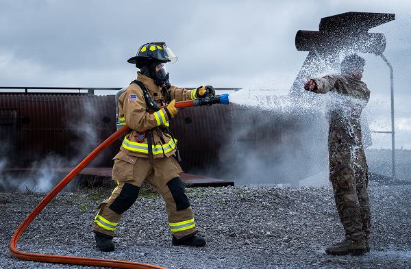 Senior Airman Axel Rojas, 96th Civil Engineer Group, hoses down Airman Aaron Patrimonio, 96th Medical Group, during mass casualty exercise Ready Eagle March 6, 2024, at Eglin Air Force Base, Fla. The exercise scenario had 96th MDG medics and firefighters respond to an explosion and take simulated casualties through the entire medical process from triage and decontamination to higher-level care. (U.S. Air Force photo by Samuel King Jr.) 