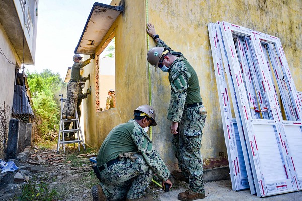 In this photo by Construction Electrician Dylan Slater, Steelworker 3rd Class Samuel Wojtowicz and Steelworker Construction Man Elam Winston take measurements of the exterior of An Tho Ninh Dong Primary School in Vietnam during a renovation project in support of Pacific Partnership 2022. Navy combat engineers used their skills to improve local conditions while honing their preparedness for the next disaster.