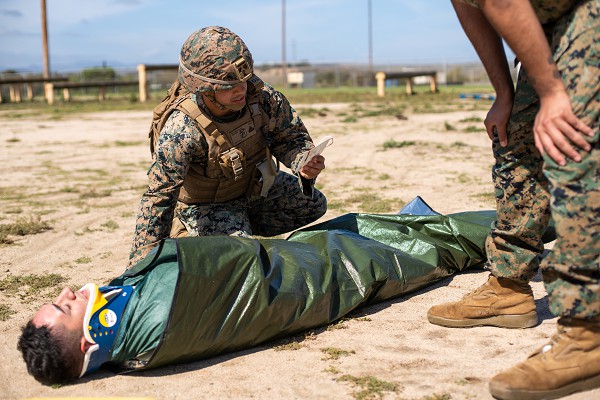 In this photo by Marine Corporal Garrett Kiger, Corporal Ryan Nascimento, a chemical, biological, radiological, and nuclear defense specialist, reads off casualty information prior to transport during a Combat Lifesaver Course practical application at Camp Pendleton.  The Combat Lifesaver Course is a three-day program that teaches Marines vital medical techniques to prevent loss of life on the battlefield. 