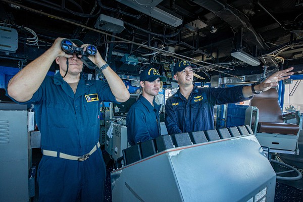 South China Sea (July 25, 2022): In this photo by Navy Mass Communications Specialist 2 Justin Stack, sailors aboard the Ticonderoga-class guided missile cruiser USS Chancellorsville stand watch for Chinese military vessels as they conduct “freedom of navigation” exercises in the Taiwan strait. America routinely confronts challenges by the Chinese Navy to the safe passage of vessels in international waters.