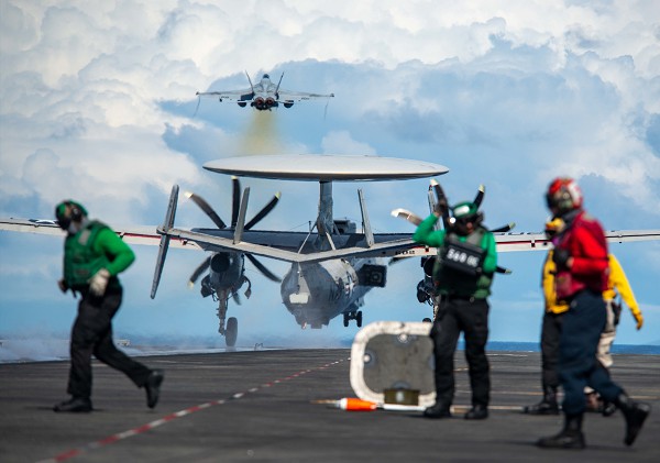 South China Sea (July 28, 2022): In this photo by Petty Officer 3rd Class Gray Gibson, an American F/A-18E Super Hornet jet attached to the “Royal Maces” Strike Fighter Squadron and an E-2D Hawkeye reconnaissance aircraft assigned to the Tiger Tails Squadron, launch from the deck of the USS Ronald Reagan aircraft carrier.  The Ronald Reagan is the Navy’s only forward-deployed aircraft carrier that conducts tactical early warning missions against hostile actors in the Indo-Pacific region.