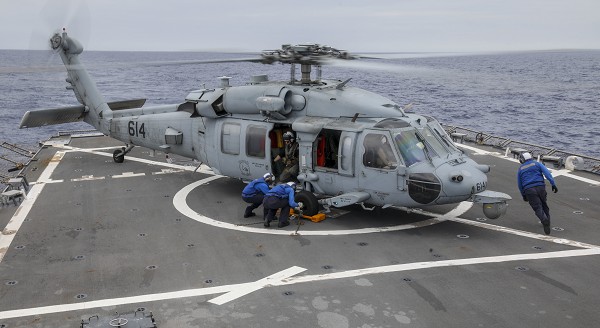 Philippine Sea (July 28, 2022): In this photo by Petty Officer 2nd Class Arthur Rosen, sailors aboard the Arleigh Burke class guided missile destroyer USS Benfold remove chocks and chains from an MH-60D Sea Hawk helicopter assigned to the famed “Golden Falcons” combat squadron. In 1951, the United States signed a Mutual Defense Pact with the Philippines guaranteeing American military intervention should any of her armed forces be attacked in contested waters.  
