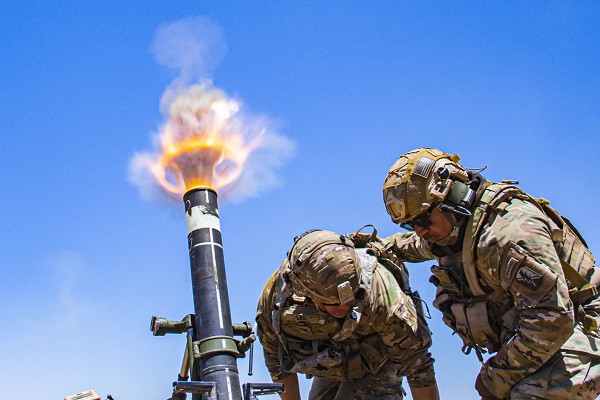 Camp Roberts, CA. (August 4, 2022): In this photo by Staff Sergeant Walter Lowell, Army Colonel Randy Lau fires a 120mm Mortar during live fire exercises at Camp Roberts, California. Mortars are the squads’ “Artillery” and these skilled crews save many lives in combat.