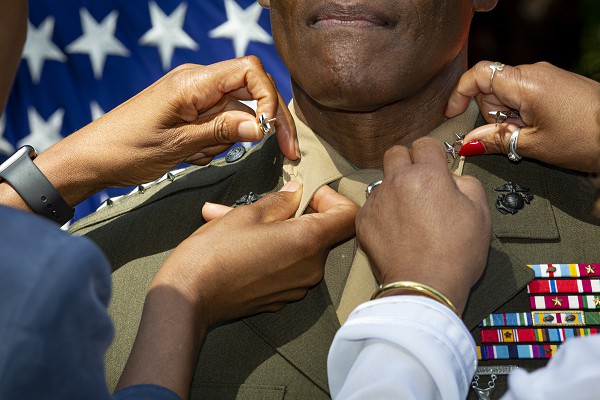 Washington, D.C. (August 12, 2022): In this photo by Sgt. Karis Mattingly, U.S. Marine Corps General Michael E. Langley is promoted by his family during a ceremony at Marine Barracks Washington, D.C.  General Langley, who began his career as an artillery officer in 1985, is the now one of only three four-star Generals in the United State Marine Corps. 